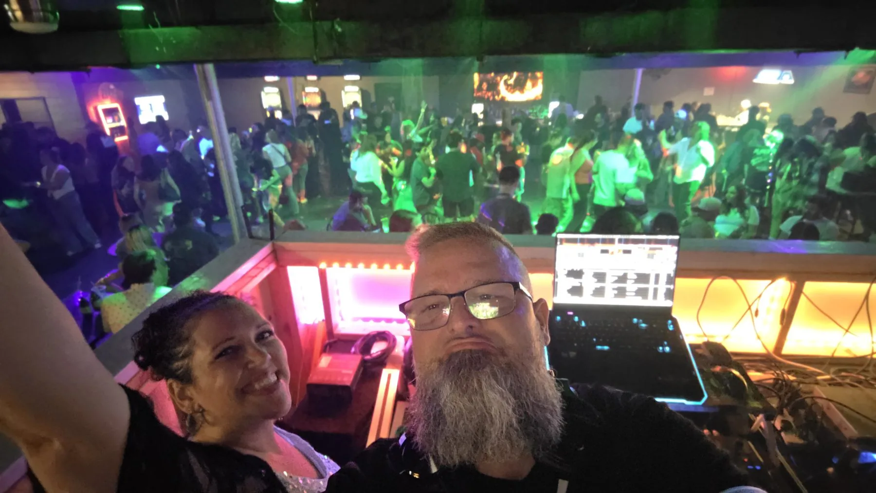 Chris and Ash at the DJ booth above a packed room