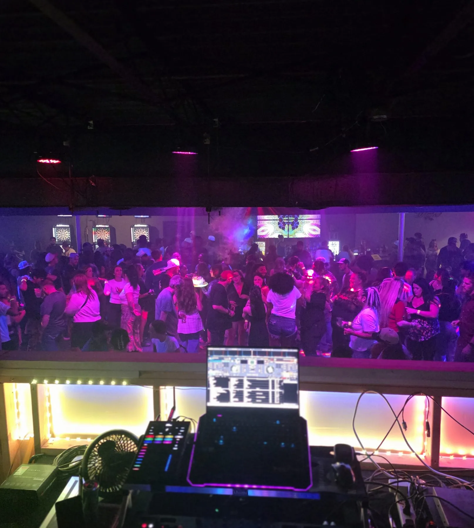 Crowded bar dance floor washed in magenta light