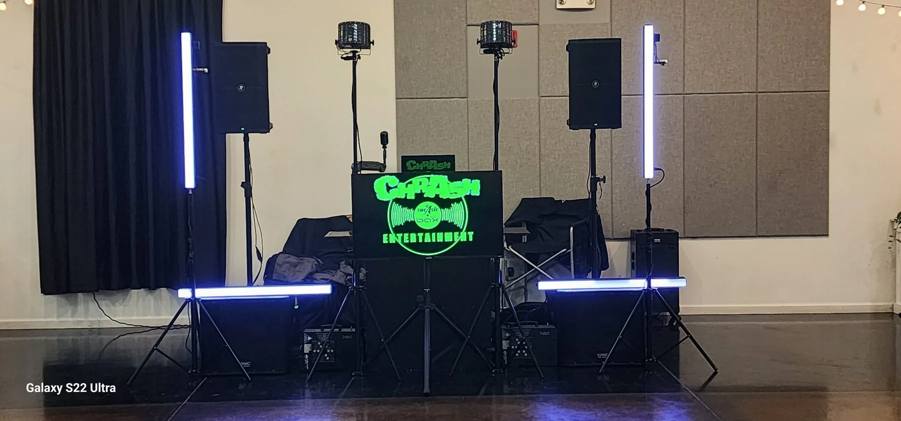 ChrAsh Entertainment DJ setup with speakers, LED tubes and a lit facade